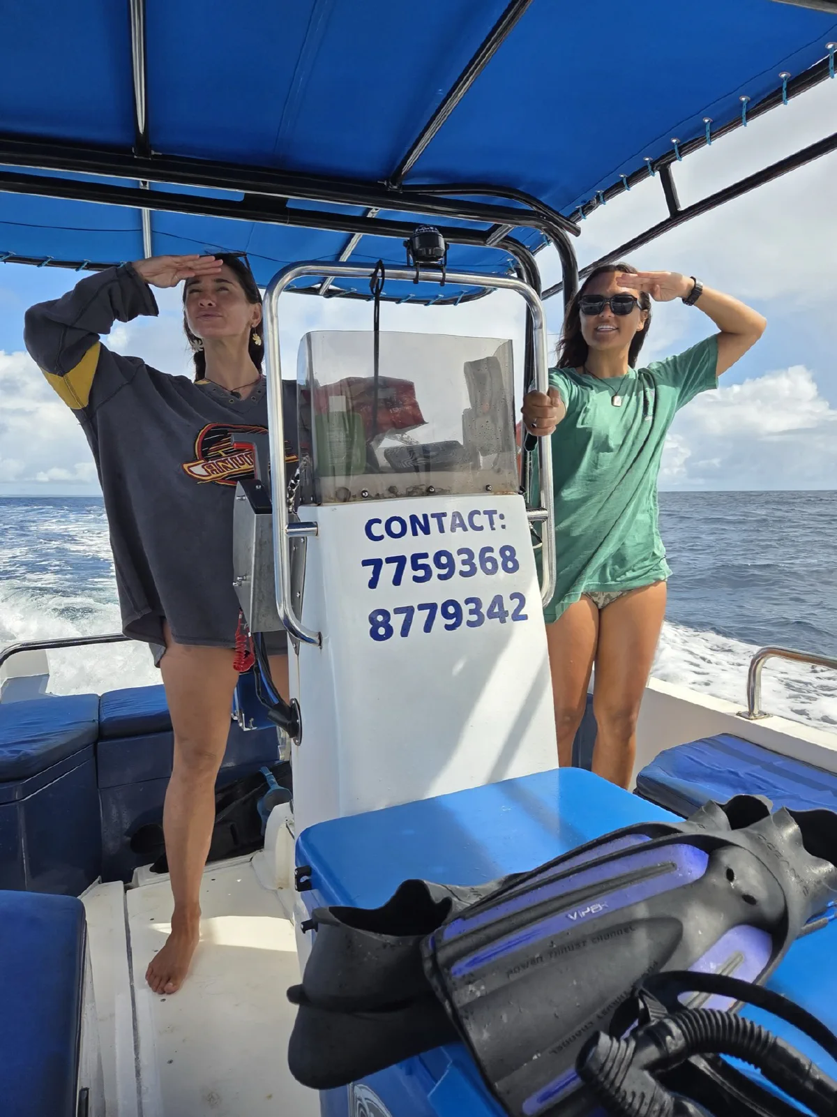 Hannah and Tee playfully saluting behind the boat's console